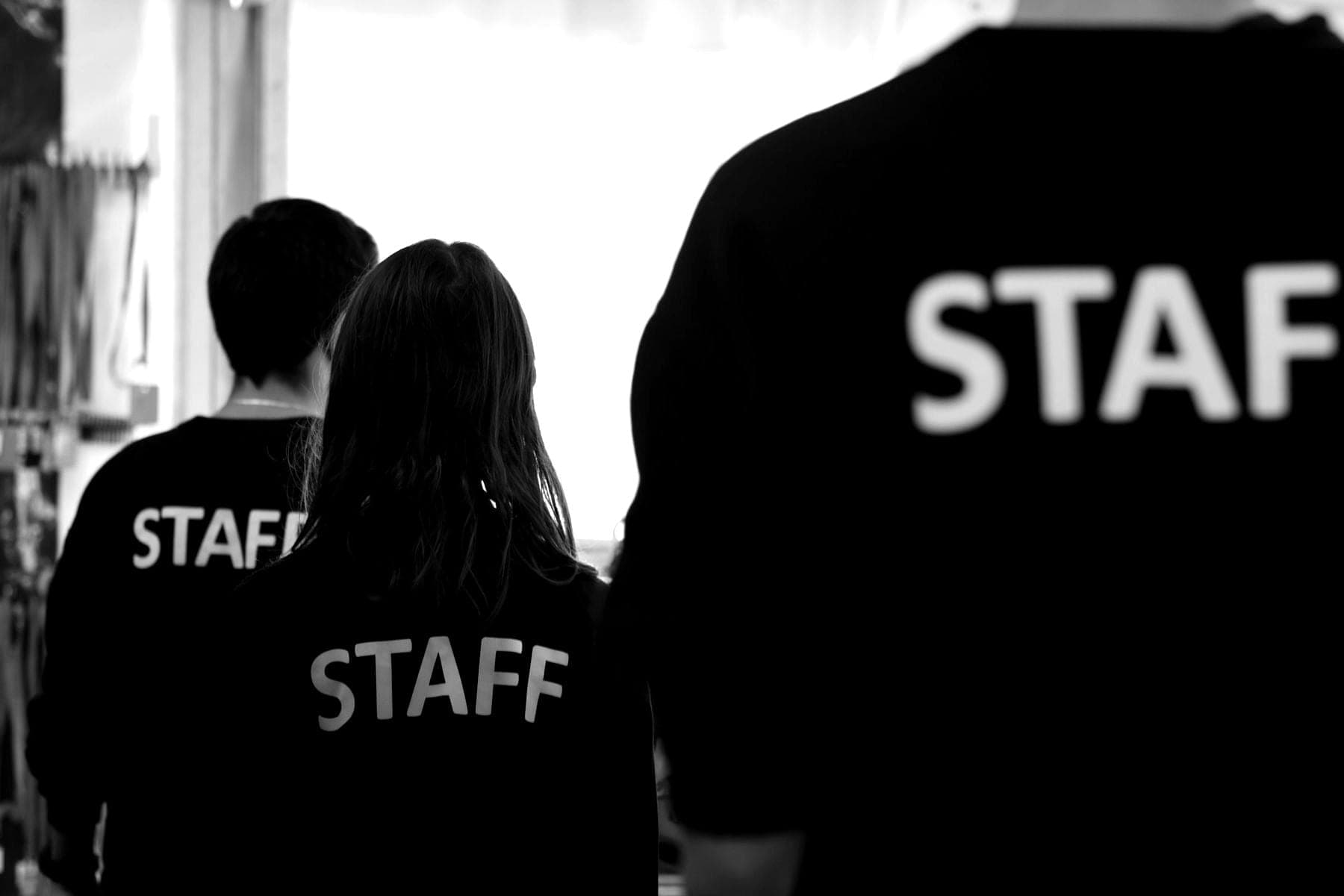Équipe en t-shirts « Staff » de dos, pendant un événement